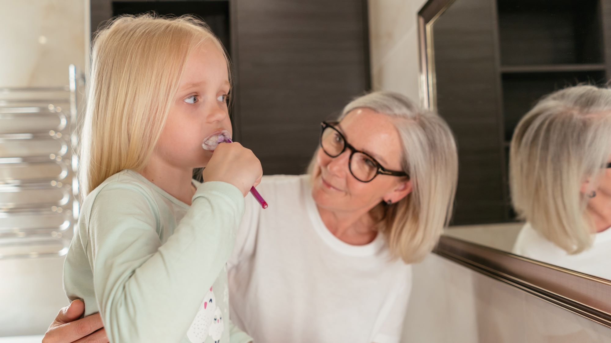 Child and mother brushing teeth.